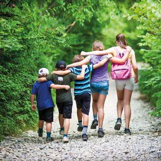 Fünf Kinder auf einem Waldweg