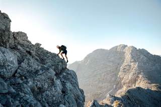 Person klettert im felsigen Gebirge