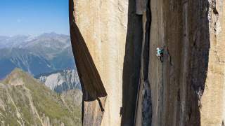 Frau klettert an senkrechter Felswand