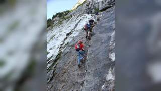 Menschen steigen Leiter eines Klettersteigs rauf