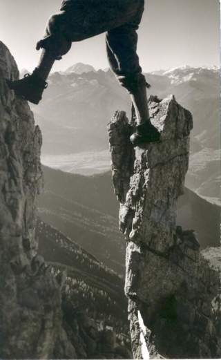 Historisches Bild eines Unterkörpers eines Bergsteigers der auf zwei Felsnadeln steht