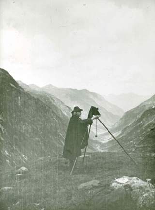 Historisches Foto eines Mannes in den Bergen beim Fotografieren