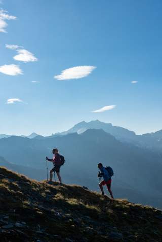 Zwei Menschen wandern über Bergwiese