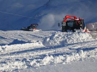 Pistenraupe in Skigebiet bei der Arbeit