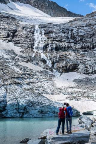Zwei Menschen stehen an Gletschersee