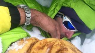 Mann überprüft Atmung bei lawinenverschütteter Person
