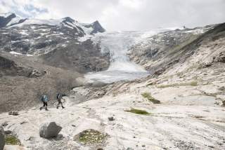 Zwei Menschen wandern in Gebirge bei Gletscher