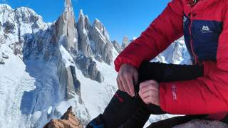 Person sitzt auf Granitgipfel.