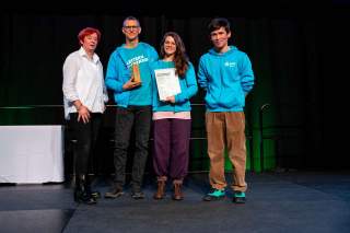 DAV-Vizepräsidentin Melanie Grimm verleiht den DAV-Preis Ehrenamt 2025 an die Initiatoren Christian Schmidt, Lena Schumacheran und Marcus Wehner des Inklusionsprojekt #KLETTERNohneGRENZEN der Sektion Bremen.