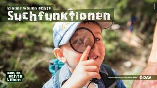 Ein Junge schaut durch ein Vergrößerungsglas