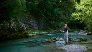 Frau beim Fliegenfischen in einem Fluss.