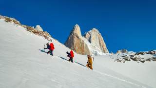 Drei Personen im steilen Aufstieg knietief im Schnee.