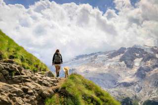 Frau und Hund auf Bergweg