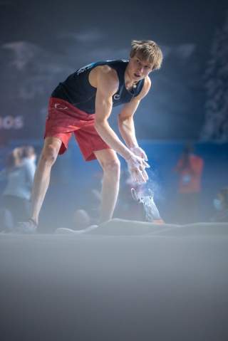 Alex Megos chalkt vor dem Versuch noch einmal nach. Foto: IFSC/Jan Virt