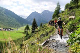 Kinder fahren mit Mountainbikes auf Trail in den Bergen