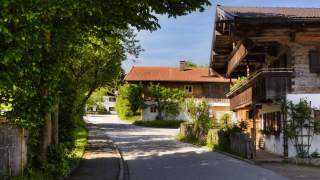 Zwei alte Bauernhöfe bei sonnigem Wetter.