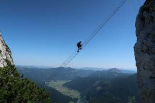 Mensch auf ausgesetzter Leiter im Klettersteig