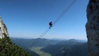 Mensch auf ausgesetzter Leiter im Klettersteig