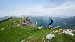 Menschen wandern auf einem Bergrücken.