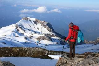Wanderin im teils noch schneebedeckten Gebirge