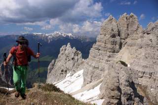 Wanderer beim Aufstieg neben steilen Felsen