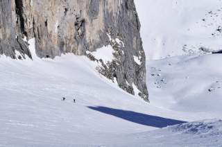 Zwei Menschen auf Skitour zwischen Felswänden