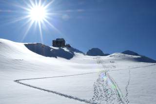 Schneebedeckte Berglandschaft mit Skitourengeher*innen
