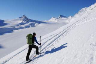 Skibergsteiger bei Aufstieg vor Gletscher