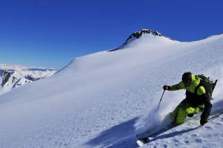 Skifahrer bei Abfahrt im Sonnenschein