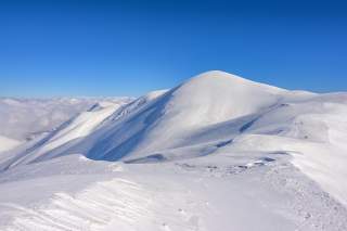 Schneebedeckte Gipfel vor blauem Himmel