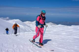 Drei Menschen auf Skitour mit Blick aufs Meer