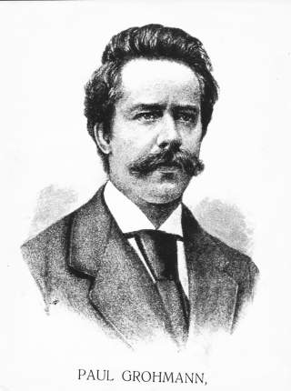 Schwarz-weiß-Porträtzeichnung eines bärtigen Mannes mit dunklem Anzug und Krawatte, darunter der Name „Paul Grohmann“.