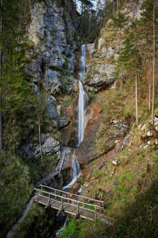 Langer Wasserfall der aus den Felswänden stürzt.