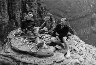Historisches Kletterbild, das eine Klettergruppe auf einem Gipfelplateau zeigt.