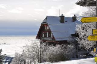 Hütte im Winter über Wolkenmeer