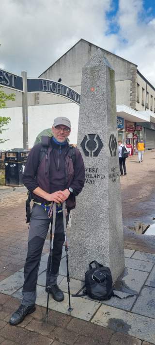 Mann steht vor Säule in kleiner Stadt