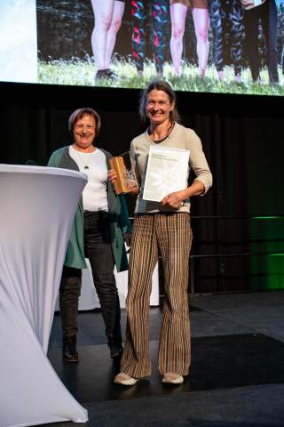 Zwei Frauen stehen bei Preisverleihung auf einer Bühne