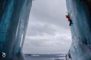 Eine Athletin klettert auf einem Eiswasserfall in Norwegen.