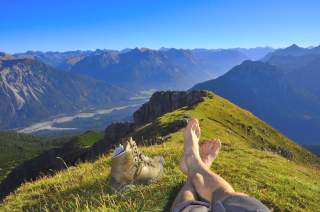 Beine auf Berggrat mit Blick auf Gipfel
