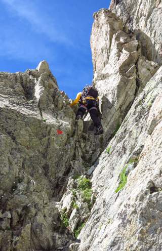 Mensch klettert Felsscharte hoch