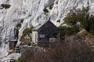 Kleine Hütte vor Felswand