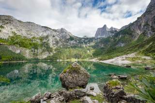 Türkisblauer Bergsee mit Gipfeln im Hintergrund