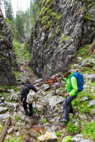 Zwei Wandernde in schmaler Felsengasse