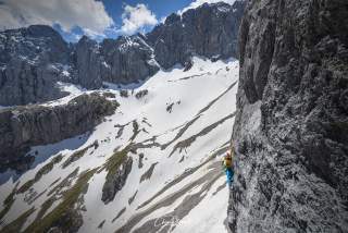 Dörte Pietron erklimmt das Zugspitzmassiv über die Route Goldkäfig. Das graue Gebirge wird von Schneefeldern geziert.