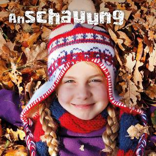 Kind liegt in Herbstlaub