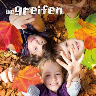 Kinder liegen im Laub.