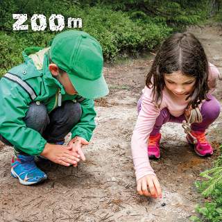Zwei Kinder auf Waldweg mit Würmern