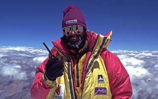 Ralf Dujmovtis steht in Expeditionsausrüstung auf dem K2 und hält ein Walkie Talkie in der Hand. Ralf Dujmovtis steht in Expeditionsausrüstung auf dem K2 und hält ein Walkie Talkie in der Hand.