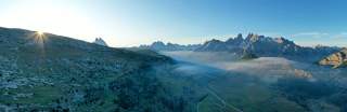 Sonnenaufgang auf Almwiese mit Bergkulisse im Hintergrund
