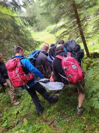 Gruppe übt Abtransport verletzter Person mit Trage